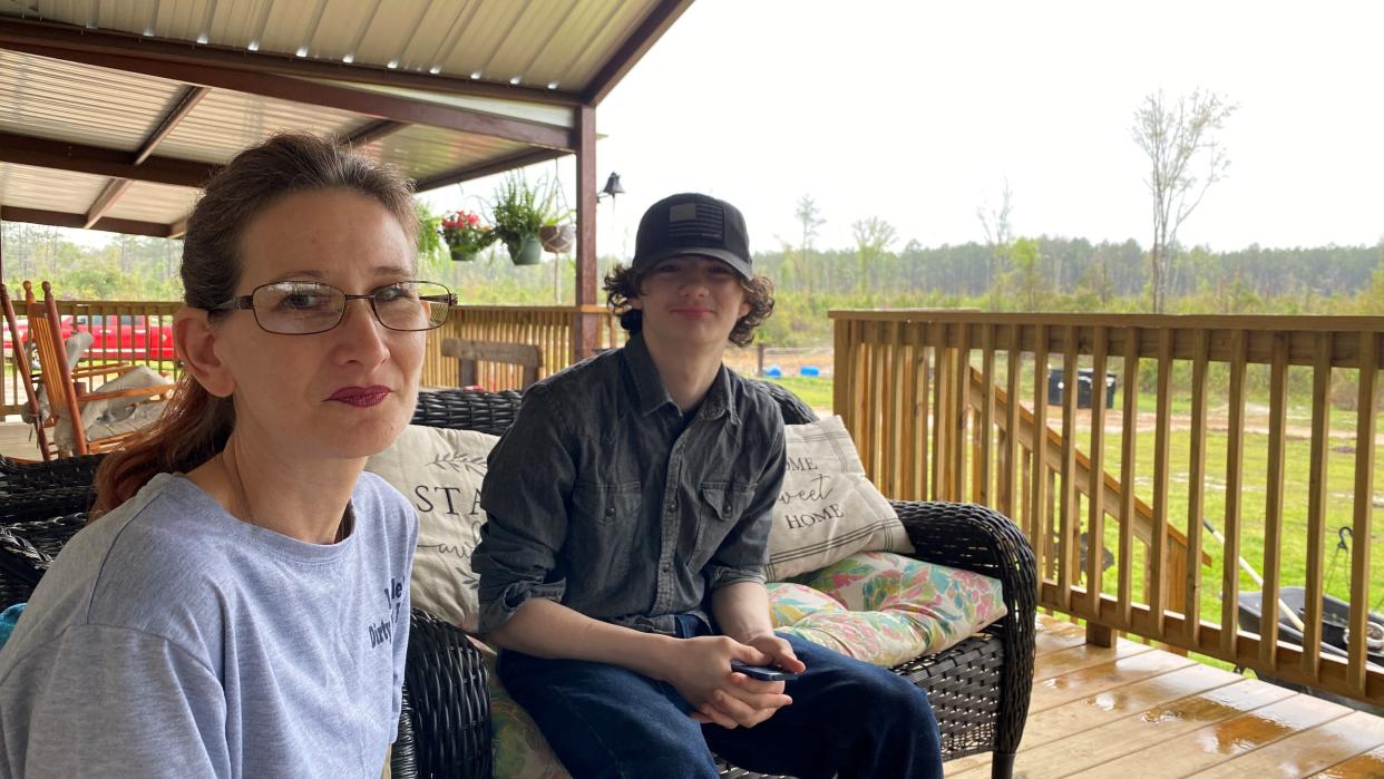 Kristen Perkins sits on the porch of her Glenmora home with one of her 14-year-old twin sons, Gus. Perkins began a dog rescue group, Leedle's Dirty Paws Rescue, after the January 2022 death of her daughter, Leeleanne Perkins.