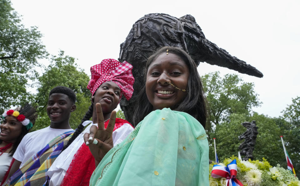 Youth in traditional clothing pose for a picture after laying wreaths at the National Slavery Monument where Mayor Femke Halsema apologized for the involvement of the city's rulers in the slave trade during a nationally televised annual ceremony in Amsterdam, Netherlands, Thursday, July 1, 2021, marking the abolition of slavery in its colonies in Suriname and the Dutch Antilles on July 1, 1863. The anniversary is now known as Keti Koti, which means Chains Broken. Debate about Amsterdam's involvement in the slave trade has been going on for years and gained attention last year amid the global reckoning with racial injustice that followed the death of George Floyd in Minneapolis last year. (AP Photo/Peter Dejong)