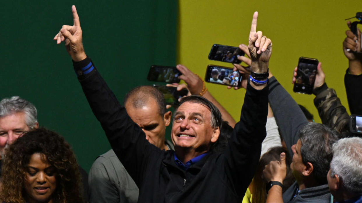 Brazilian President and re-election candidate Jair Bolsonaro greets supporters during a rally in Santos some 60 km from Sao Paulo Brazil on September 27 2022. - Brazil entered the final stretch of the presidential campaign, a high voltage electoral duel between archrivals Jair Bolsonaro and Luiz Inácio Lula da Silva that, according to polls, could be defined already in the first round on October 2 in favor of the former president. (Photo by NELSON ALMEIDA / AFP)