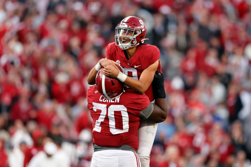 Offensive lineman Javion Cohen (70), then at Alabama, lifts quarterback Bryce Young after Young threw a touchdown pass against Arkansas.