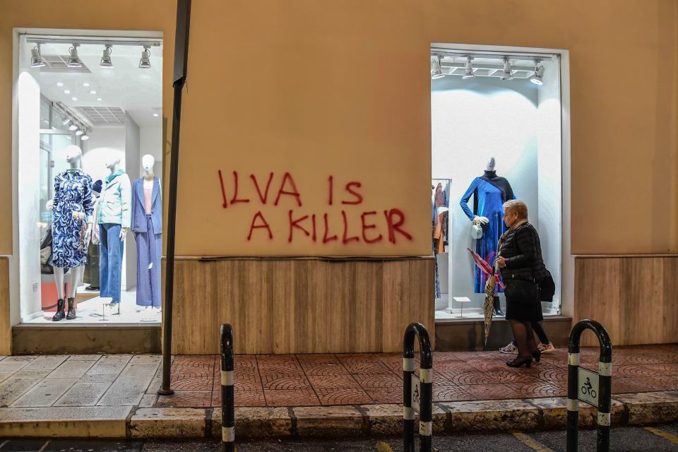 A resident walks past a clothes shop in central Taranto, southern Italy,  on November 7, 2019, with a tag refering to the city's steel manufacturing giant Arcelor Mittal Italia (ex ILVA ) plant. - The world steel giant ArcelorMittal announced on November 4, 2019 that it was cancelling the takeover of the Italian company Ilva, after the withdrawal of criminal environmental protection for the managers of the Taranto site, which is currently being cleaned up. (Photo by Andreas SOLARO / AFP) (Photo by ANDREAS SOLARO/AFP via Getty Images)