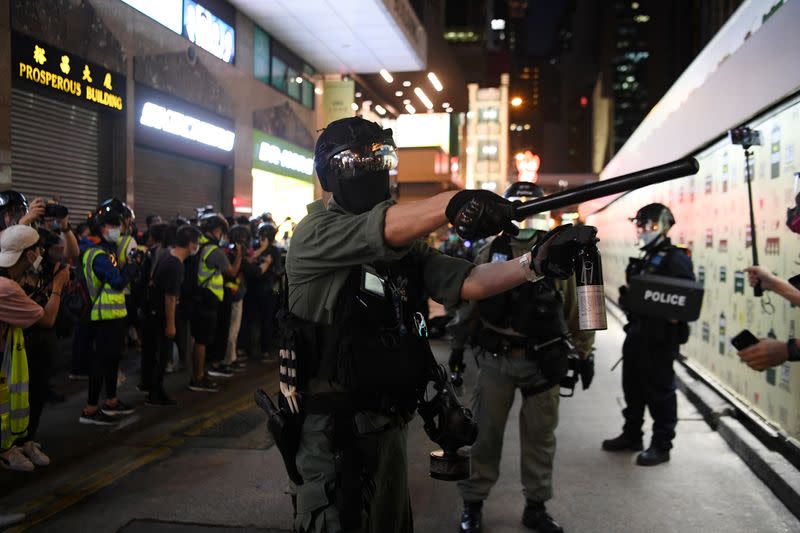 Police warn journalists to move back during a protest in Hong Kong