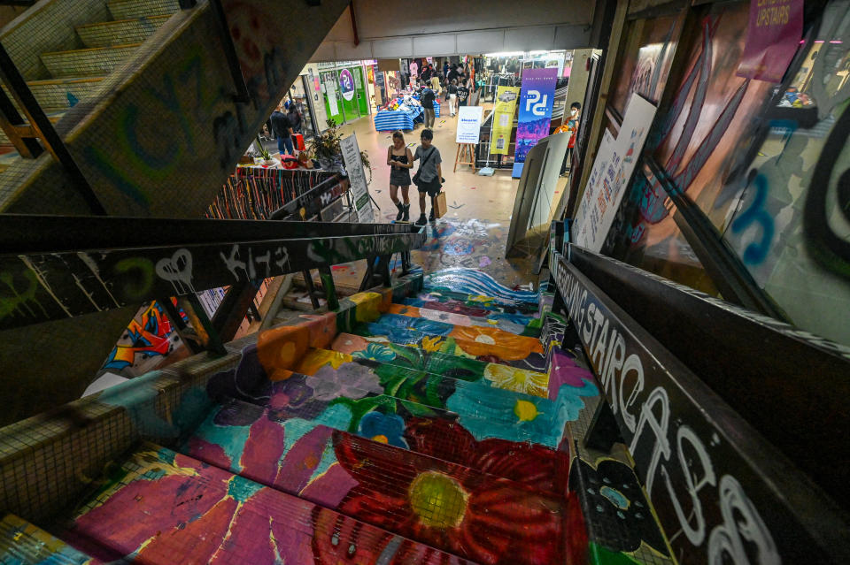 Shoppers walk past drawings and grafitti at the Peace Centre, an abandoned mall turned into an unexpected art enclave in Singapore.