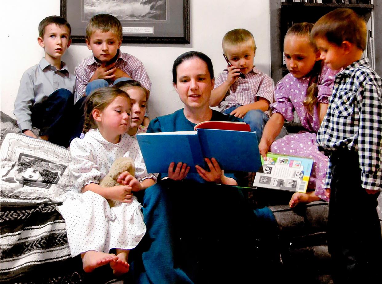 This undated photo provided by Robert Krause shows his daughter, Sasha Krause, center, reading a book to children. Krause was killed in early 2019.