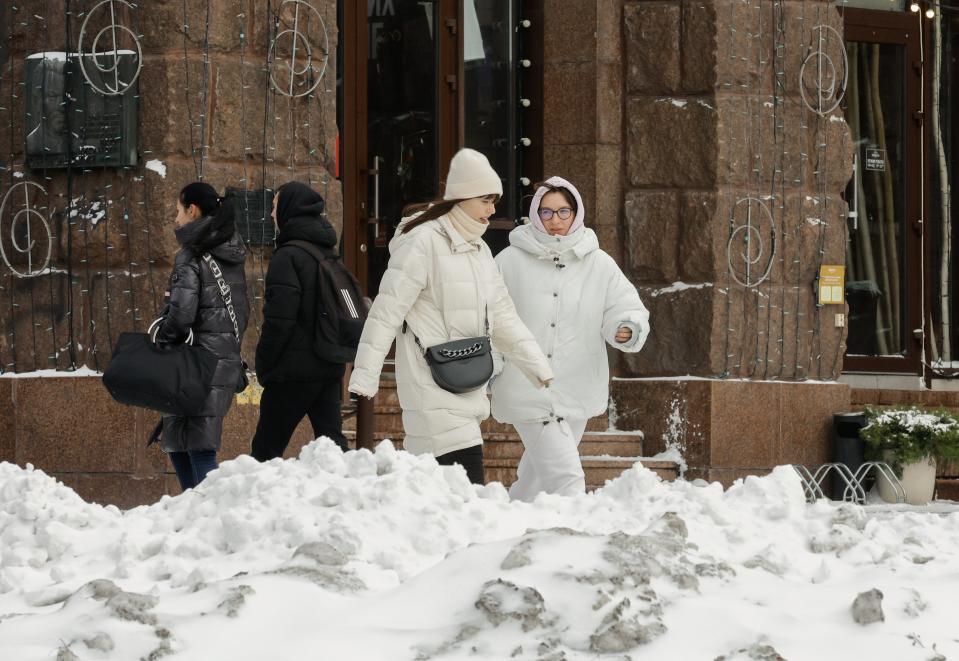 Pedestrians make they way along a pavement cleared of snow in Kyiv (EPA)