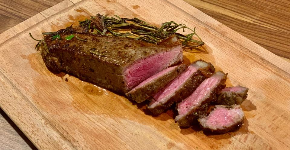 the steak sliced on a wood cutting board