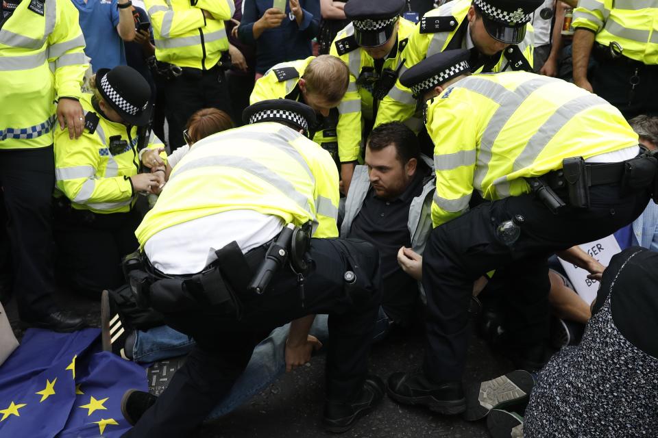 Police arrest anti-Brexit demonstrators during a sit-down protest in London, Saturday, Aug. 31, 2019. Crowds gathered in London and other major British cities to protest Prime Minister Boris Johnson's suspension of Parliament for part of the period before the Brexit deadline in two months. (AP Photo/Alastair Grant)