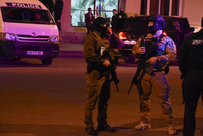 Law enforcement officers gather in a street near a branch of the Bank of Georgia after a gunman took hostages in Zugdidi