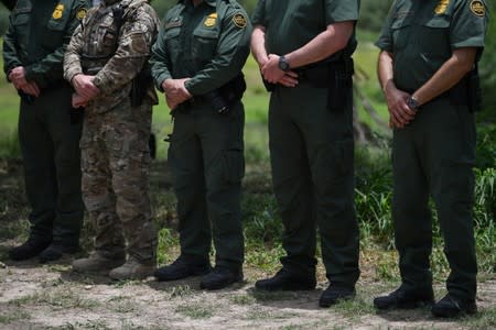 U.S. Border Patrol agents stand at attention during a 'Border Safety Initiative' media event at the U.S.-Mexico border in Mission