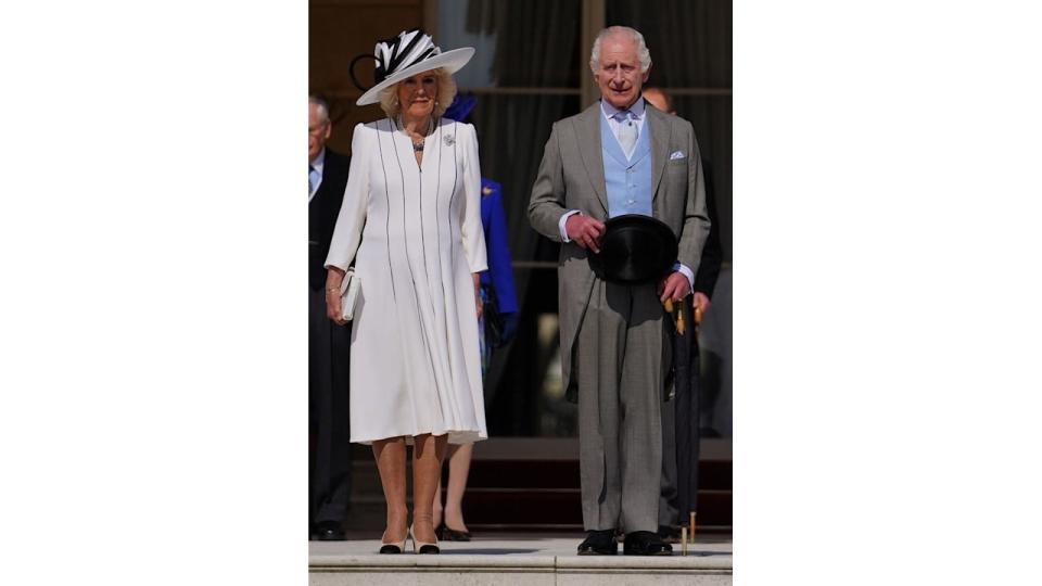 Queen Camilla in black and white dress and hat with King Charles