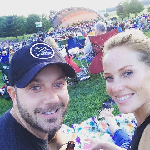 <p>Mina Starsiak Hawk Instagram</p> Mina Starsiak Hawk taking a selfie with her husband Steve Hawk at an outdoor event.