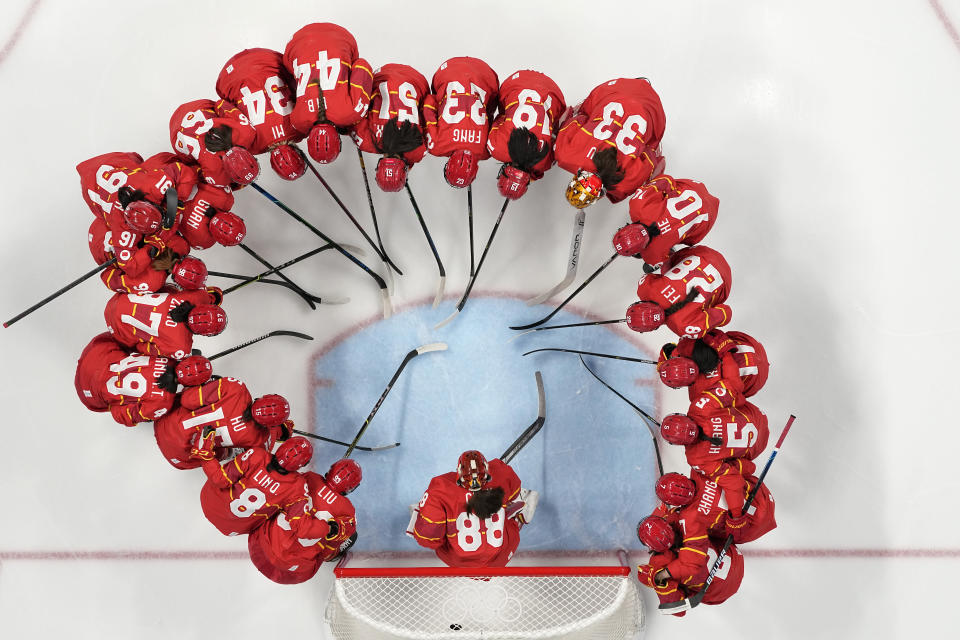 The Chinese team gathers around goalkeeper Tiya Chen (88) before a preliminary round women's hockey game against Czech Republic at the 2022 Winter Olympics, Thursday, Feb. 3, 2022, in Beijing. (AP Photo/Petr Josek)
