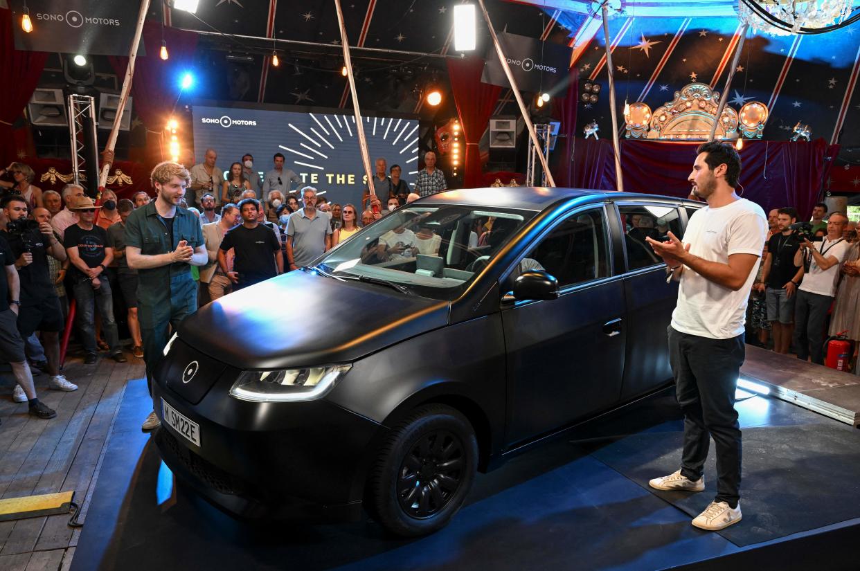 The Sion car, a solar electric vehicle (SEV) developed by Sono Motors, is surrounded by viewers in Munich, southern Germany, on July 25, 2022, during the unveiling of the final series production design. - The 