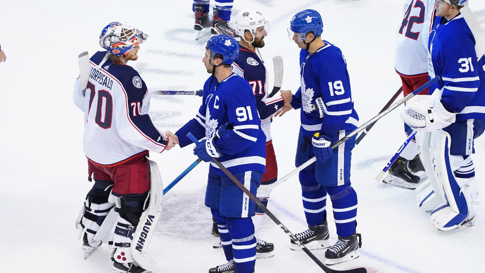 TORONTO, ONTARIO - AUGUST 09: Joonas Korpisalo #70 and Nick Foligno #71 of the Columbus Blue Jackets shake hands with John Tavares #91 and Jason Spezza #19 of the Toronto Maple Leafs after winning 3-0  in Game Five of the Eastern Conference Qualification Round prior to the 2020 NHL Stanley Cup Playoffs at Scotiabank Arena on August 09, 2020 in Toronto, Ontario. (Photo by Andre Ringuette/Freestyle Photo/Getty Images)