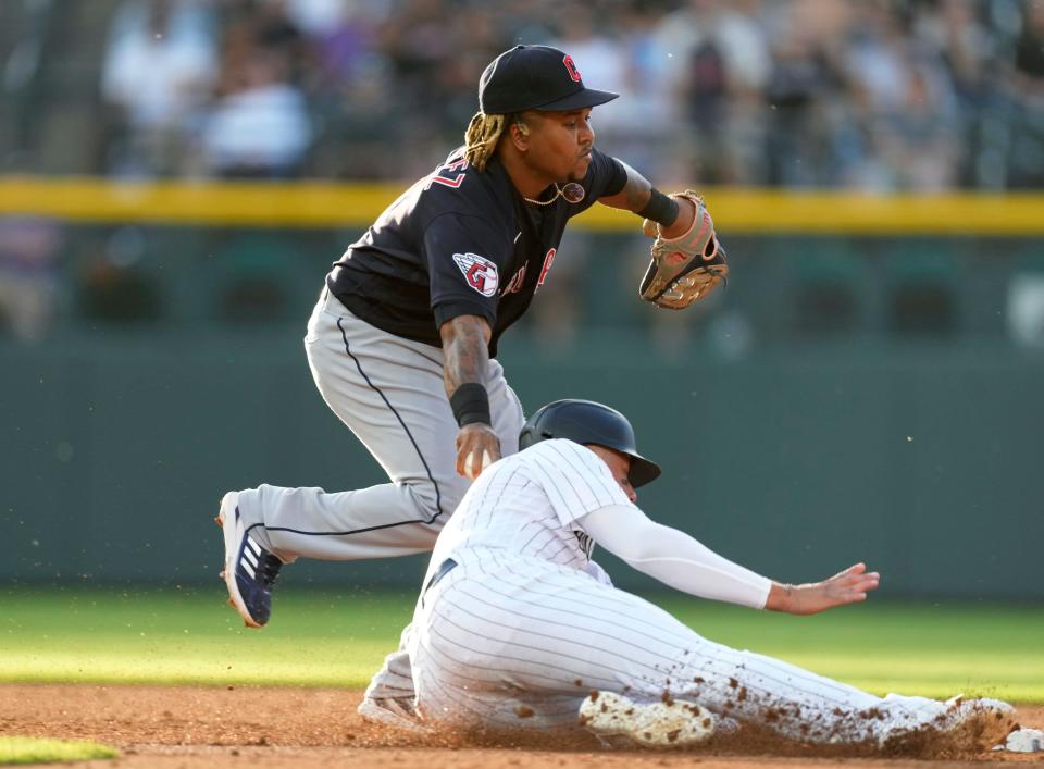 Guardians third baseman Jose Ramirez, back, tags out Colorado Rockies runner Yonathan Daza, who was caught in a rundown between second and third in the third inning of Tuesday night's game in Denver. The Guardians won 4-3 in 10 innings. [David Zalubowski/Associated Press]