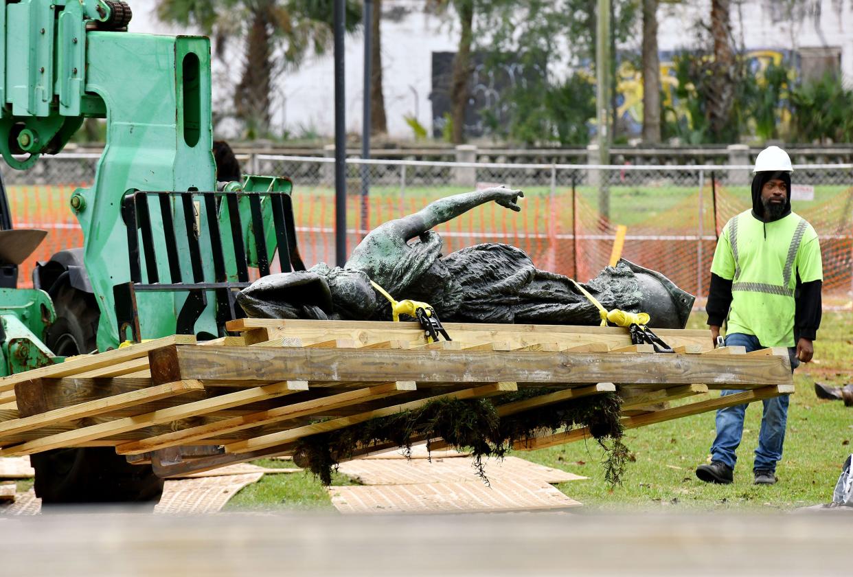 The bronze statue of a women with a Confederate flag is moved to a waiting flatbed truck after it was removed from the top of the "Women of the Southland" monument Wednesday. Crews removed the Confederate statues, plaques and pedestal from the monument, also known as the "Tribute to the Women of the Southern Confederacy," on Dec. 27.