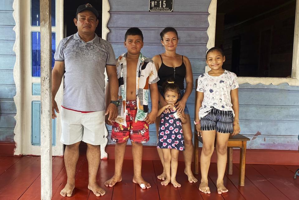 Laurimar Lopes Alves, who goes by Caboclo, poses for a photo with his family at their home in Benjamin Constant, Amazonas state, Brazil, March 2, 2023. One year ago, Caboclo met Bruno Pereira, an expert on Indigenous communities, and Dom Phillips, a British journalist, shortly before their murders. The Associated Press returned to the Javari Valley ahead of the anniversary to describe the place where the two were killed. (AP Photo/Fabiano Maisonnave)