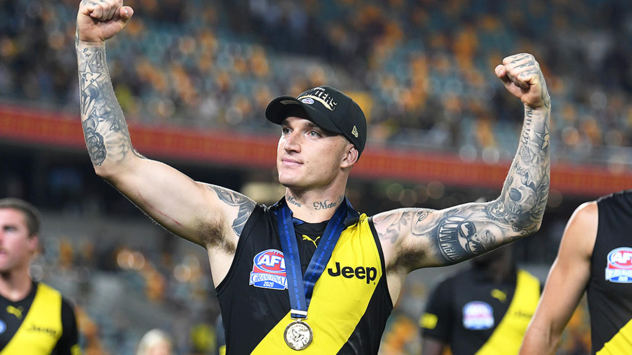 Pictured here, Dustin Martin flexes his muscles after winning a third Norm Smith Medal.