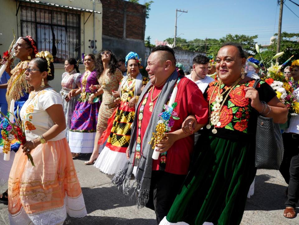 Muxes march arm in arm at a parade