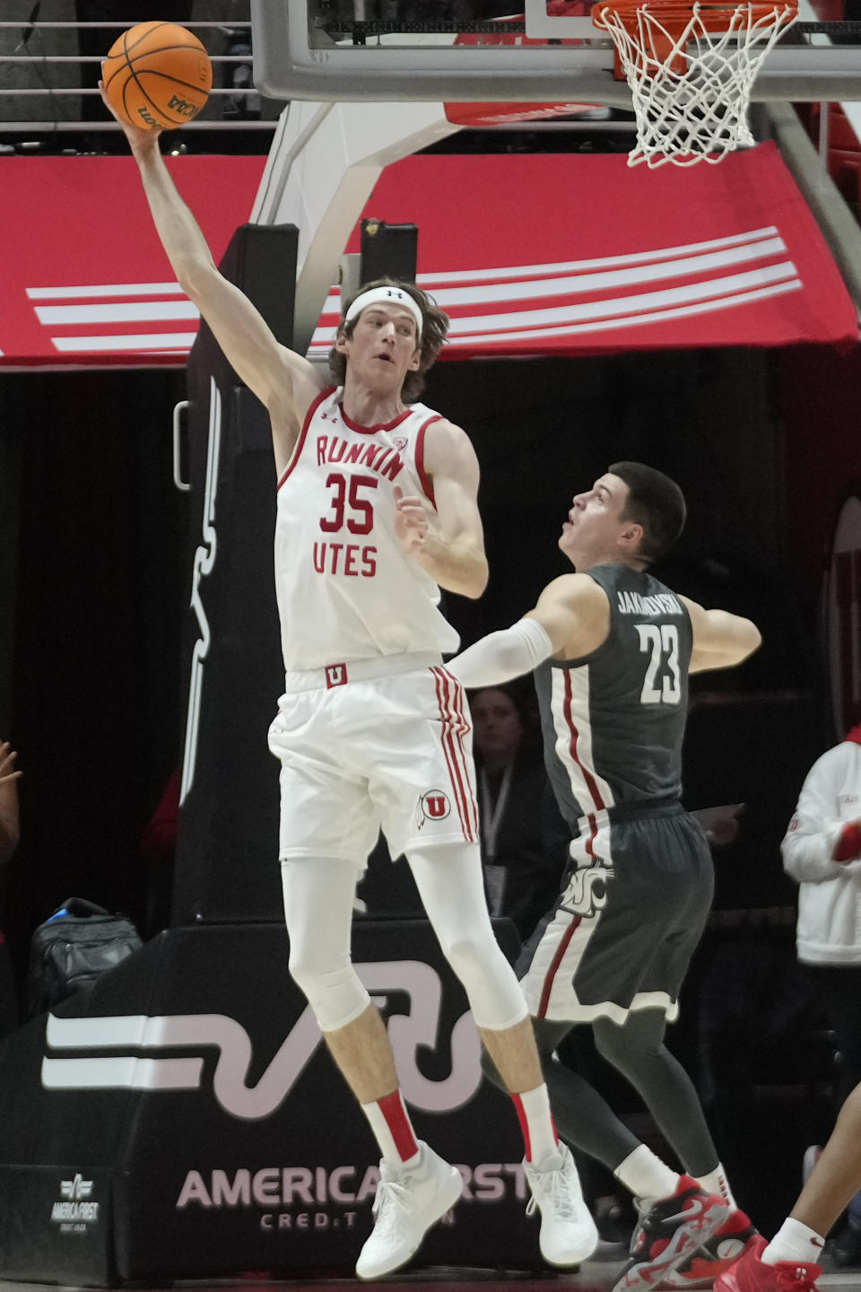 Utah center Branden Carlson (35) reaches for a pass as Washington State forward Andrej Jakimovski (23) defends during the first half of an NCAA college basketball Friday, Dec. 29, 2023, in Salt Lake City. (AP Photo/Rick Bowmer)