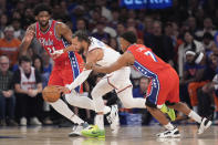 New York Knicks guard Jalen Brunson, center, drives against Philadelphia 76ers center Joel Embiid (21) and guard Kyle Lowry (7) during the first half in Game 1 of an NBA basketball first-round playoff series, Saturday, April 20, 2024, at Madison Square Garden in New York. (AP Photo/Mary Altaffer)