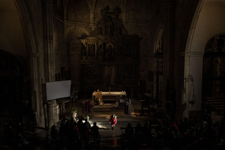 A girl walks through a shaft of light in the church of Morales del Vino during the celebration of a special catechesis for both children and parents in Morales del Vino, in the Zamora province of Spain, Saturday, Nov. 27, 2021. Zamora has lost 16% of its population since 2000. (AP Photo/Manu Brabo)