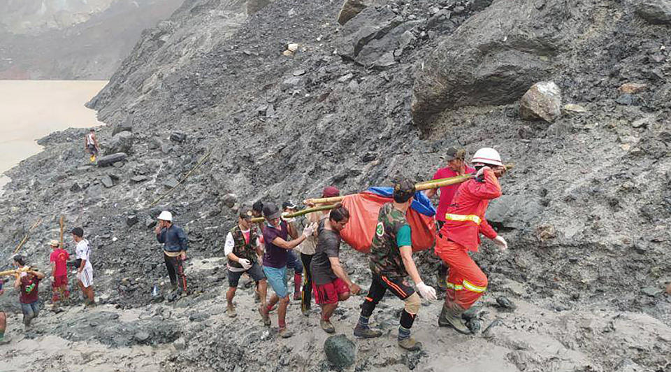 Image: Rescuers carry a recovered body of a victim of a landslide from a jade mining area in Hpakant, Kachine state, northern Myanmar (Myanmar Fire Service Department / AP)