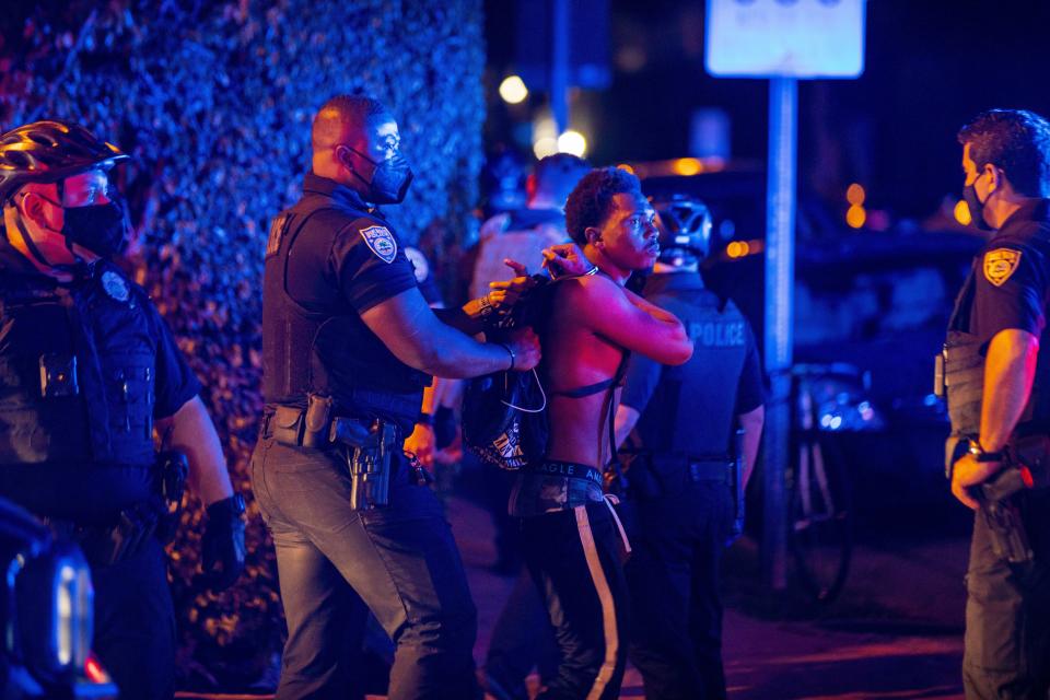 A man is arrested while out a few hours past curfew in Miami Beach, Fla., on Sunday, March 21, 2021. Miami Beach commissioners voted unanimously Sunday to extend the 8 p.m. to 6 a.m. curfew Thursday through Sunday in the South Beach entertainment district until at least April 12, effectively shutting down a spring break hot spot in one of the few states fully open during the pandemic. (Daniel A. Varela/Miami Herald via AP)