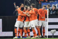 Netherland's Virgil Van Dijk is celebrated by his team after scoring his side's second goal in the 90th minute during the UEFA Nations League soccer match between Germany and The Netherlands in Gelsenkirchen, Monday, Nov. 19, 2018. The match ended 2-2. (AP Photo/Martin Meissner)