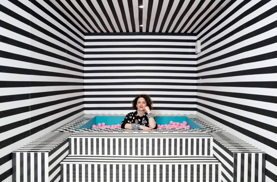 Here, Camille sits in the visually vibrating striped Jacuzzi tub.