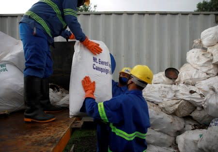 Workers from a recycling company load the garbage collected and brought from Mount Everest in Kathmandu