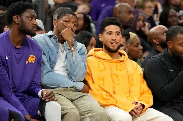 Phoenix Suns guard Bradley Beal, blue shirt, and guard Devin Booker, yellow shirt, watch from the bench during the second half of the team's NBA basketball game against the Utah Jazz, Saturday, Oct. 28, 2023, in Phoenix. (AP Photo/Rick Scuteri)