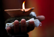 <p>A lit oil lamp is placed on the hand of a devotee while offering prayers during “Dashain”, a Hindu religious festival in Bhaktapur, Nepal, Sept. 30, 2017. (Photo: Navesh Chitrakar/Reuters) </p>