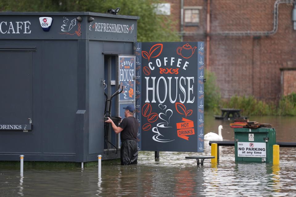 A man moves furniture out of flood water in Wellingborough (Joe Giddens/PA Wire)