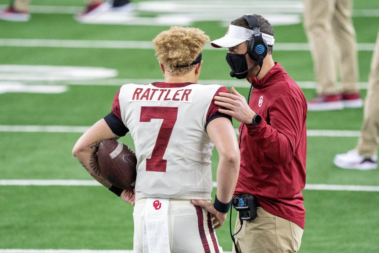 Oklahoma head coach Lincoln Riley talks with quarterback Spencer Rattler (7) before the Big 12 Conference championship NCAA college football game against Iowa State, Saturday, Dec. 19, 2020, in Arlington, Texas. (AP Photo/Jeffrey McWhorter)