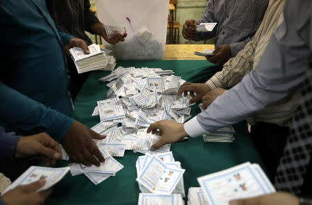 Electoral workers sort ballots to count votes after polls closed during the presidential election in Cairo, Egypt, March 28, 2018. REUTERS/Ammar Awad