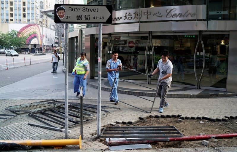 Municipality workers clean the debris of Sunday's anti-government protest in Hong Kong