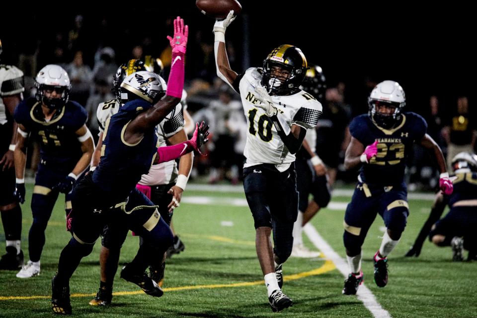 Newark's Keyon Black (10) looks to pass under pressure from DMA's Odell Teel in Delaware Military Academy's 28-14 victory over Newark, Friday, October 27 at Fusco Field in Wilmington.