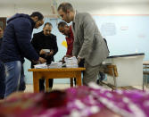 In front of inked tissues, election workers count ballots at the end of three-day vote of the referendum on constitutional amendments at polling station in Cairo, Egypt, Monday, April 22, 2019. Egyptians are voting on constitutional amendments that would allow el-Sissi to stay in power until 2030.(AP Photo/Amr Nabil)