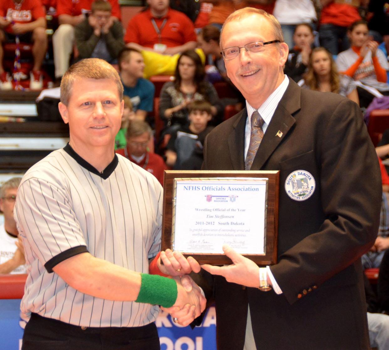 Tim Steffensen of Watertown is shown receiving the National Federation of High Schools Wrestling Official of the Year Award from Wayne Carney in 2011-12. Steffensen is one of nine people set to be inducted into the South Dakota Wrestling Coaches Associations Hall of Fame on Saturday, Feb. 24 during the State Individual Wrestling Championships at Sioux Falls.