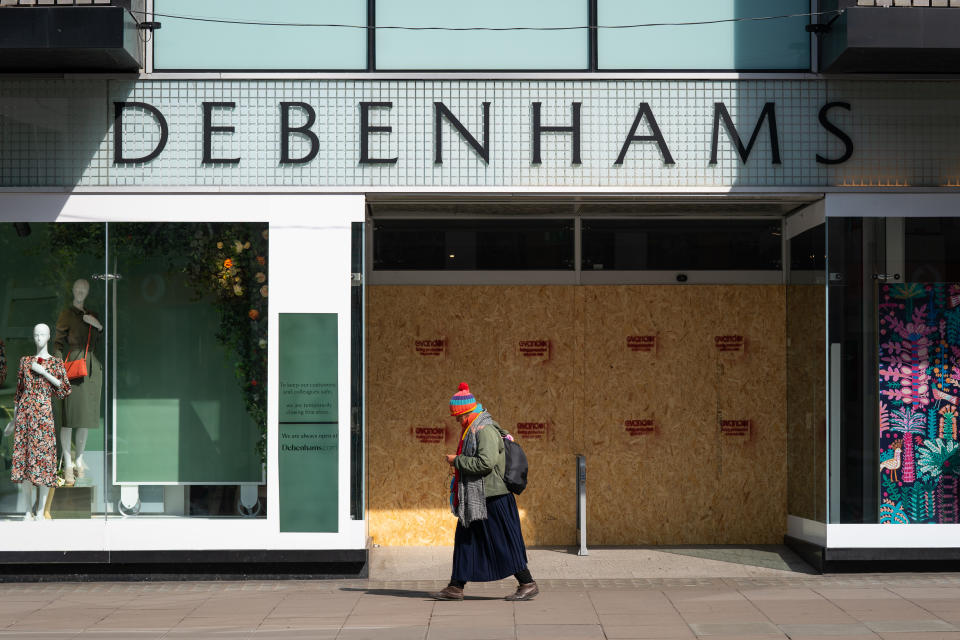A person walks past a boarded up Debenhams, Oxford Street, London as the UK continues in lockdown to help curb the spread of the coronavirus.
