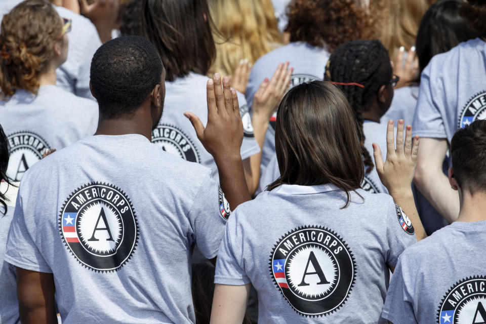 FILE- In this Sept. 12, 2014 file photo, as President Barack Obama and former President Bill Clinton mark the 20th anniversary of the AmeriCorps national service program, hundreds of new volunteers are sworn in for duty at a ceremony on the South Lawn of the White House in Washington. Hundreds of Teach for America alumni are slamming the educator placement program for telling members to cross the picket line during a potential teacher strike in Oakland, California, or risk losing thousands of dollars at the end of their service. In partnership with the AmeriCorps, Teach for America members can apply for an education award at the end of their service to help pay off student loans. An AmeriCorps spokeswoman couldn't immediately provide comment but said striking is prohibited. (AP Photo/J. Scott Applewhite, File)