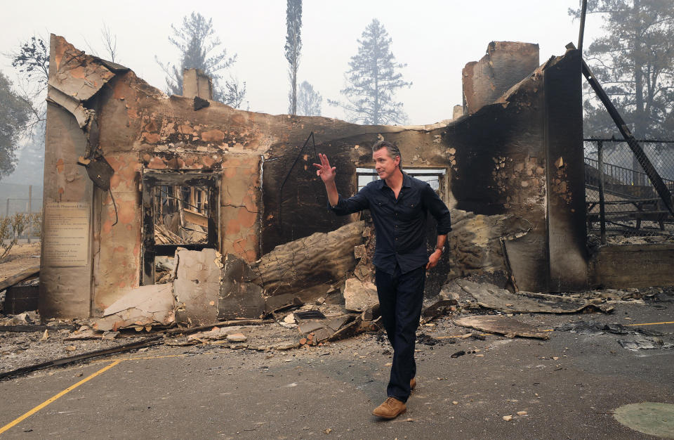 California Governor Gavin Newsom waves as he leaves the burned portion of Foothills Elementary School following a press conference near St. Helena, Calif., Thursday, Oct. 1, 2020. (Christopher Chung/The Press Democrat via AP, Pool)