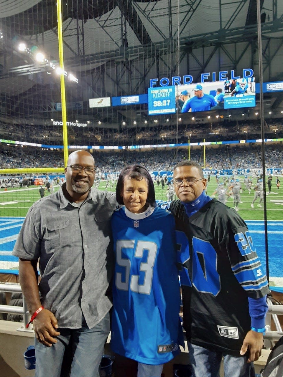 Vania Hall, center, and her husband, Chris, right, with former Lions offensive lineman Kevin Glover pose at Ford Field on Monday, Oct. 30, 2023, when the Lions hosted the Las Vegas Raiders.