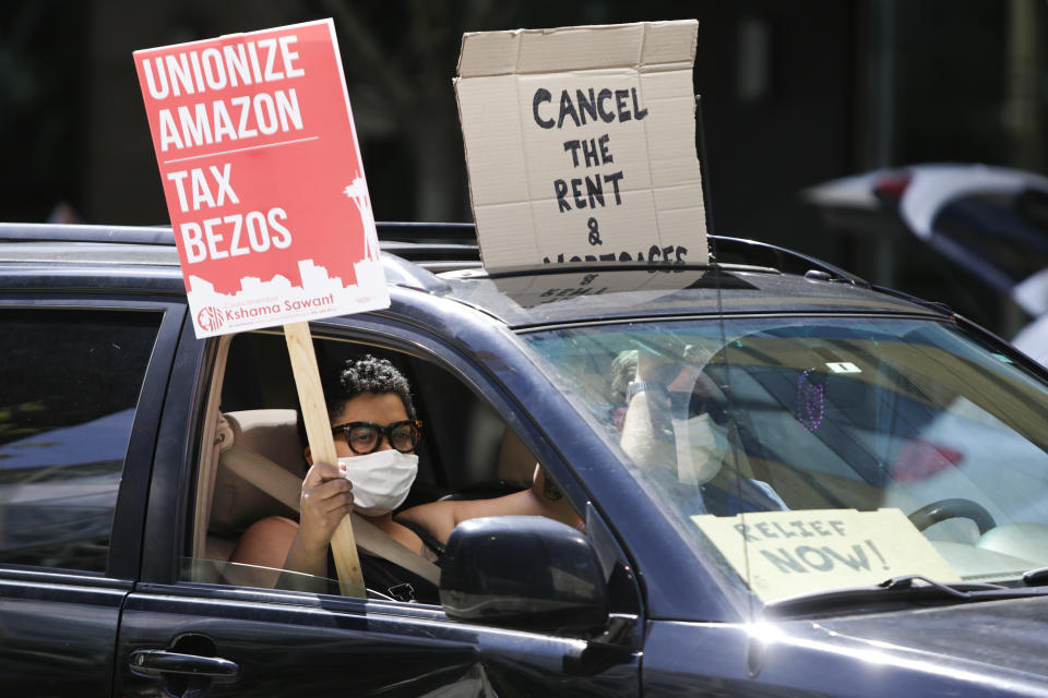 People drive around the block with anti-Jeff Bezos signs as they participate in a "car caravan" protest at the Amazon Spheres to demand the Seattle City Council tax the city's largest businesses in Seattle, Washington on May 1, 2020. - U.S. employees of Amazon, its supermarket subsidiary Whole Foods and supermarket delivery services were called to strike on May 1, taking advantage of May 1 to denounce employers accused of not sufficiently protecting them in the face of the pandemic. (Photo by Jason Redmond / AFP) (Photo by JASON REDMOND/AFP via Getty Images)