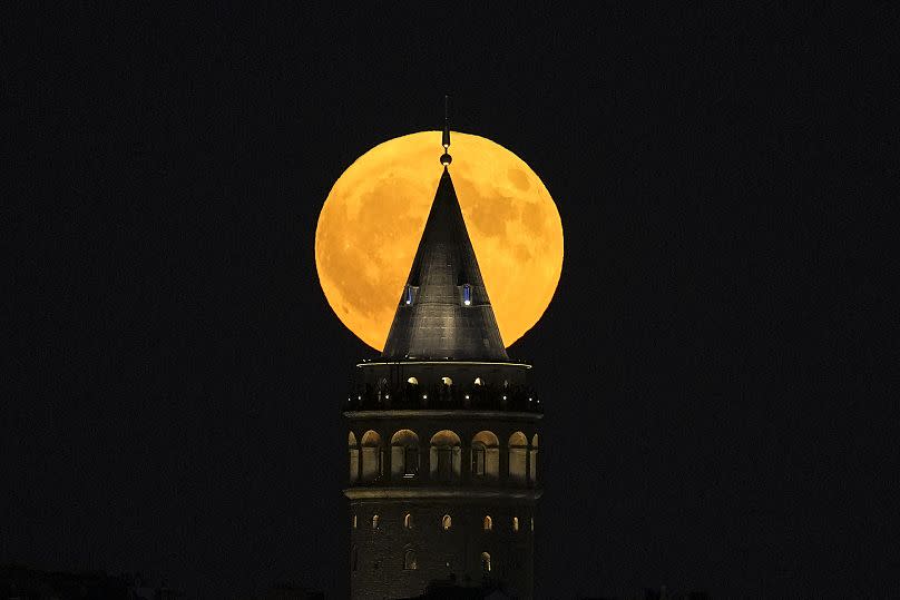 A supermoon rises behind the Galata Tower in Istanbul, Turkey, Monday, Aug. 19, 2024.