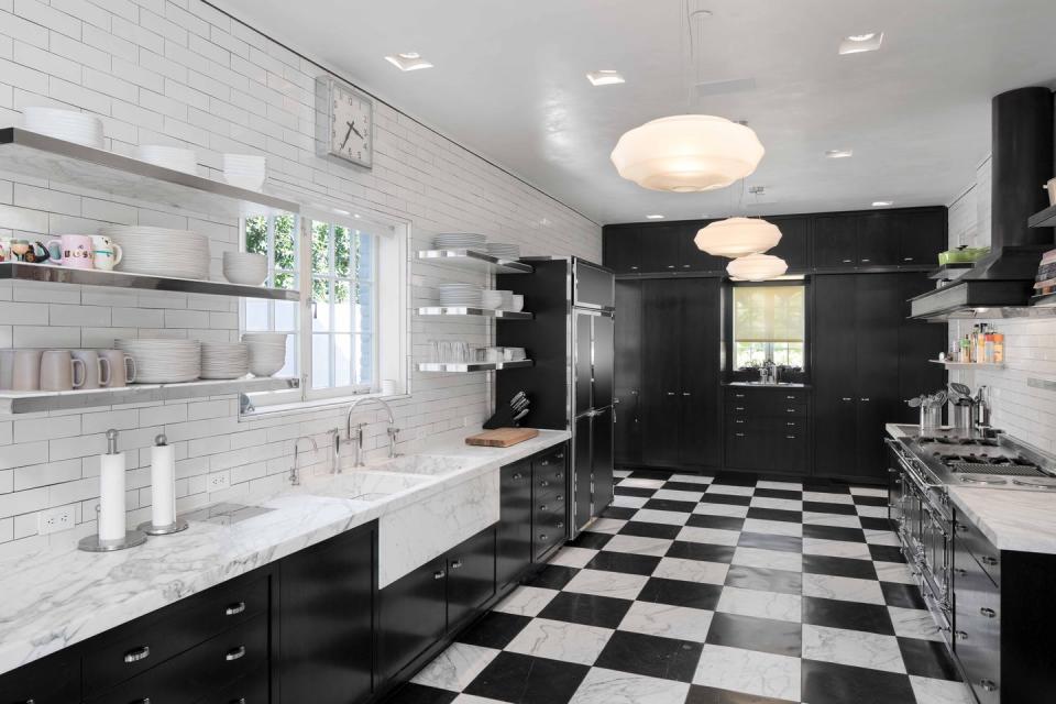 7) The sleek black and white kitchen has heated marble flooring.