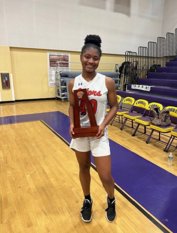 Palm Beach Gardens’ top scorer of the game Kyana Poitier poses with the district championship trophy after leading the Gators (15-8) to a 47-45 victory over Palm Beach Lakes. (14-8)