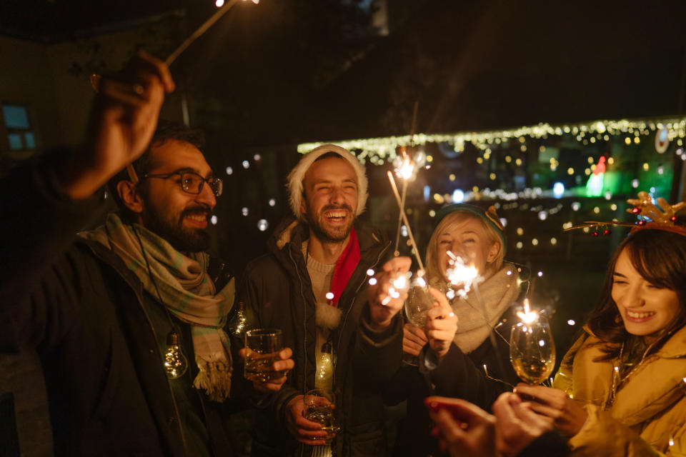 Photo of a cheerful group of friends, at an outdoor Christmas celebration.