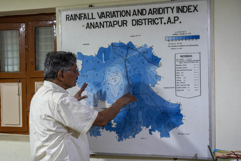 Malla Reddy, who runs Accion Fraterna Ecology Centre, an organization that encourages farmers to take up natural farming, explains the reasons why Anantapur district is among the driest regions in the country using a rainfall variation and aridity map at his office in the town of Anantapur, India, Tuesday, Sept. 13, 2022. “It was always a dry region but we knew when it will rain and people used to farm accordingly,” Reddy said. (AP Photo/Rafiq Maqbool)